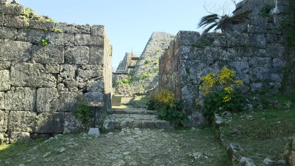 中城城跡の堅牢な石垣と石段、黄色いツワブキの花