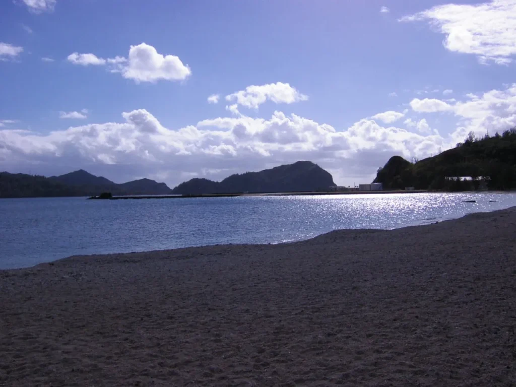 父島の中心部にある大村海岸の穏やかな波打ち際と山並み