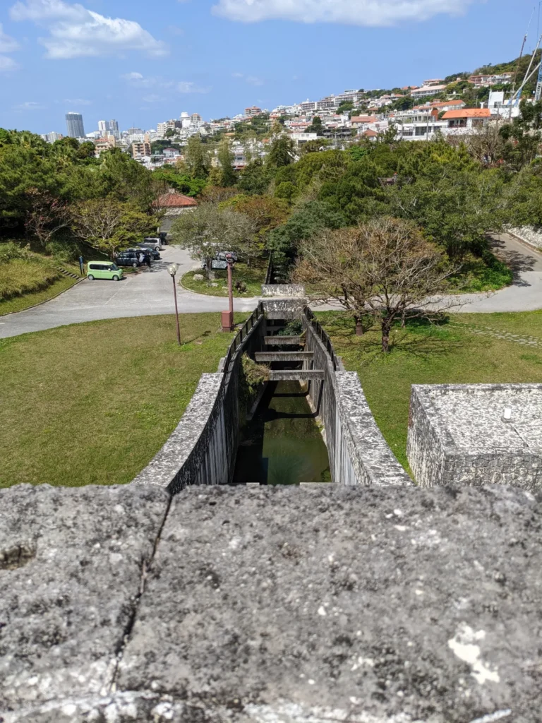 金城ダムの上から見下ろす公園と那覇の街並み