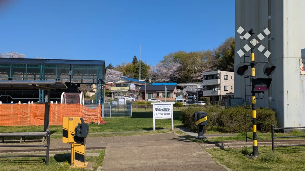 ミニSLの「栗山公園駅」。ホームも踏切もある本格的な駅。奥にD51が展示されている。右の橋脚は京成の高架。
