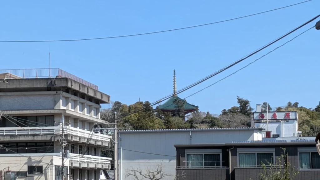 電車道で撮影した一枚。住宅の屋根越しに成田山の塔が顔を出している。